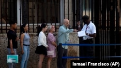 FOTO ARCHIVO. Cubanos hacen fila frente a la embajada de Estados Unidos en La Habana el día de su reapertura para los servicios consulares y de visas. (AP Foto/Ismael Francisco)