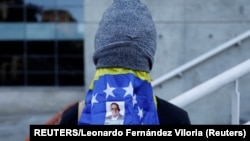 Un manifestante se cubre con una bandera durante una vigilia en homenaje a los ciudadanos detenidos, tras los controvertidos resultados electorales, en Caracas, Venezuela. (REUTERS/Leonardo Fernández Viloria)