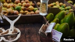 Un vendedor ambulante sostiene un mazo de pesos en una calle de La Habana. (REUTERS/Alexandre Meneghini)