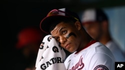 Juan Soto, de los Nacionales de Washington, se limpia la cara en el banquillo antes de un partido este domingo contra los Bravos de Atlanta. (Foto AP/Nick Wass)