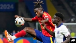 El español Nico Williams compite por el balón con el inglés Bukayo Saka, a la derecha, durante el partido final entre España e Inglaterra en el torneo de fútbol Euro 2024.