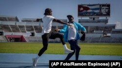 El deportista cubano Maykel Masoo se prepara con su entrenador Daniel Osorio en La Habana, Cuba, el viernes 1 de julio de 2022