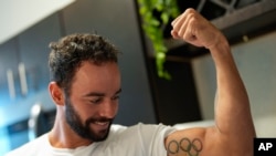 Fernando Dayán Jorge muestra un tatuaje olímpico en su bíceps, el 26 de junio de 2024, en Cape Coral, Florida. El Comité Olímpico Cubano exigió la “exclusión inmediata” de un atleta isleño del equipo de refugiados en los Juegos Olímpicos de París. (Foto AP/Rebecca Blackwell)