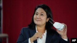 La candidata presidencial Keiko Fujimori se retira su mascarilla el miércoles 9 de junio de 2021 durante una conferencia de prensa, en Lima, Perú. (AP Foto/Martín Mejía)