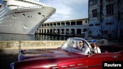 Un auto de alquiler frente a un crucero anclado en la Bahía de La Habana.