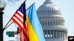 Las banderas de Ucrania, Estados Unidos y el Distrito de Columbia ondean en la Avenida Pensilvania cerca del Capitolio. (AP Foto/J. Scott Applewhite)