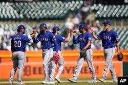 El primera base de los Rangers de Texas Ezequiel Durán (20), de izquierda a derecha, Adolis García, Josh Smith, Marcus Semien y Corey Seager celebran tras vencer a los Tigres de Detroit en un partido de béisbol, el jueves 18 de abril de 2024, en Detroit. (AP Photo/Paul Sancya)