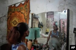 Maricelys Colás posa en su cuarto en la ruinosa mansión de la calle Villegas. Esta jubilada de 64 años vive en la casa con su madre de 85 años desde hace 59 años. (Foto AP/Ramón Espinosa)