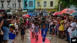 Niños caminan por la pasarela en un desfile de moda de peinados afro en La Habana, Cuba, el sábado 31 de agosto de 2024. (Foto AP/Ramon Espinosa)